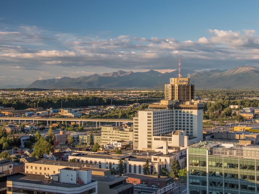 Uitzicht op het centrum van Anchorage, Alaska met de bergen op de achtergrond – reizen met Explore.