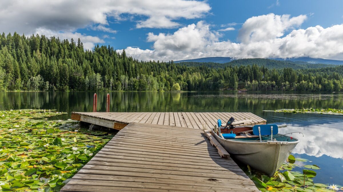 Boot aan houten steiger op een rustig meer in Wells Gray Provincial Park, Canada – reizen met Explore