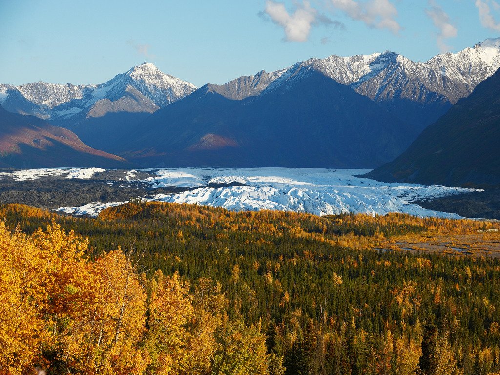 Zicht op de Matanuska-gletsjer tussen herfstbossen en bergtoppen in Alaska – reizen met Explore