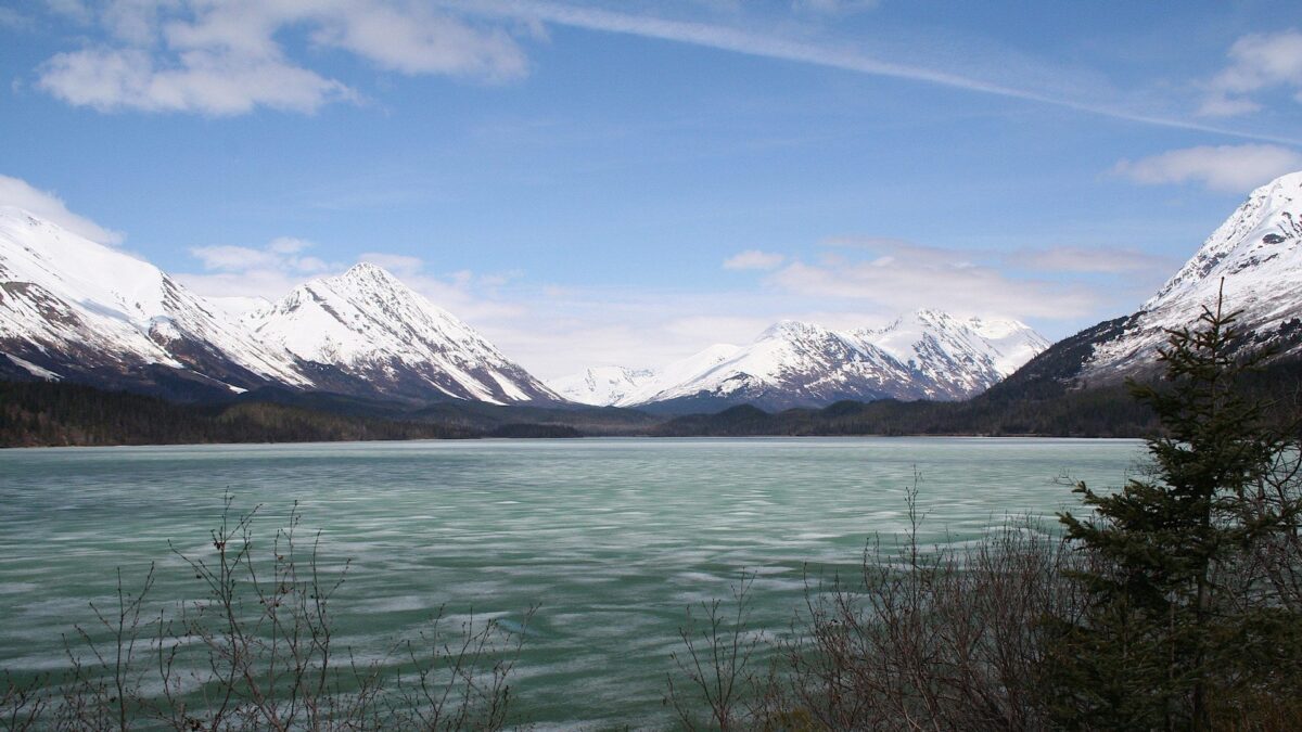 Bevroren meer omringd door besneeuwde bergen bij Moose Pass in Alaska – reizen met Explore