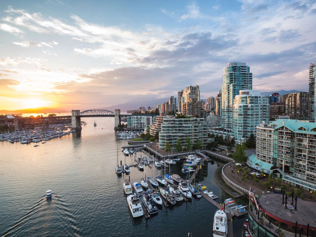 Zonsondergang over de skyline van Vancouver met jachthaven en brug, Canada – reizen met Explore.
