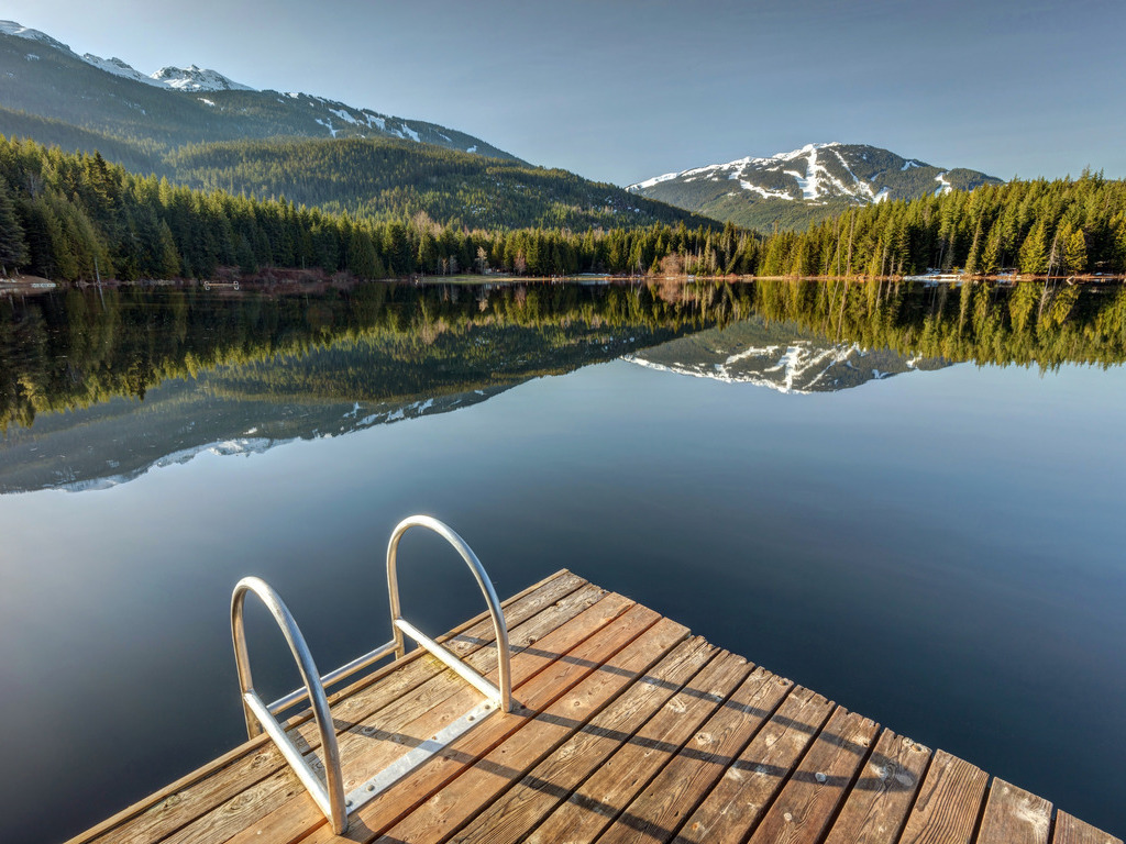 Steiger aan Lost Lake met uitzicht op de bergen bij Whistler, British Columbia, Canada – reizen met Explore.