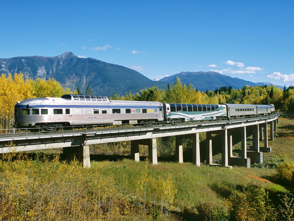 Via Rail Canada trein op een brug bij Jasper National Park, met herfstbossen en bergen – Canada – reizen met Explore.