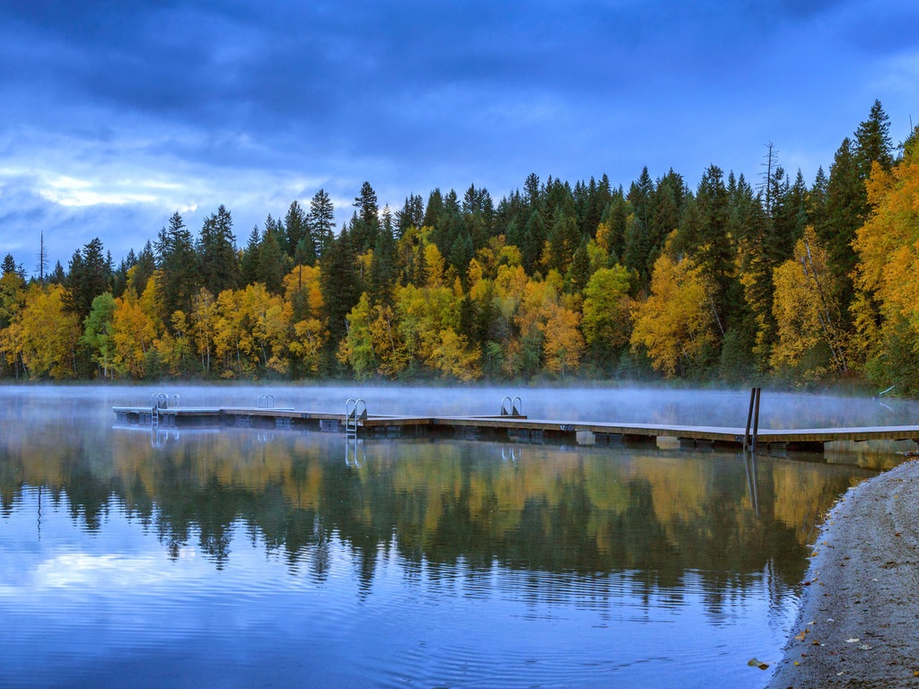 Steiger op mistig meer met herfstkleurige bomen, Wells Gray Provincial Park, Canada – reizen met Explore.