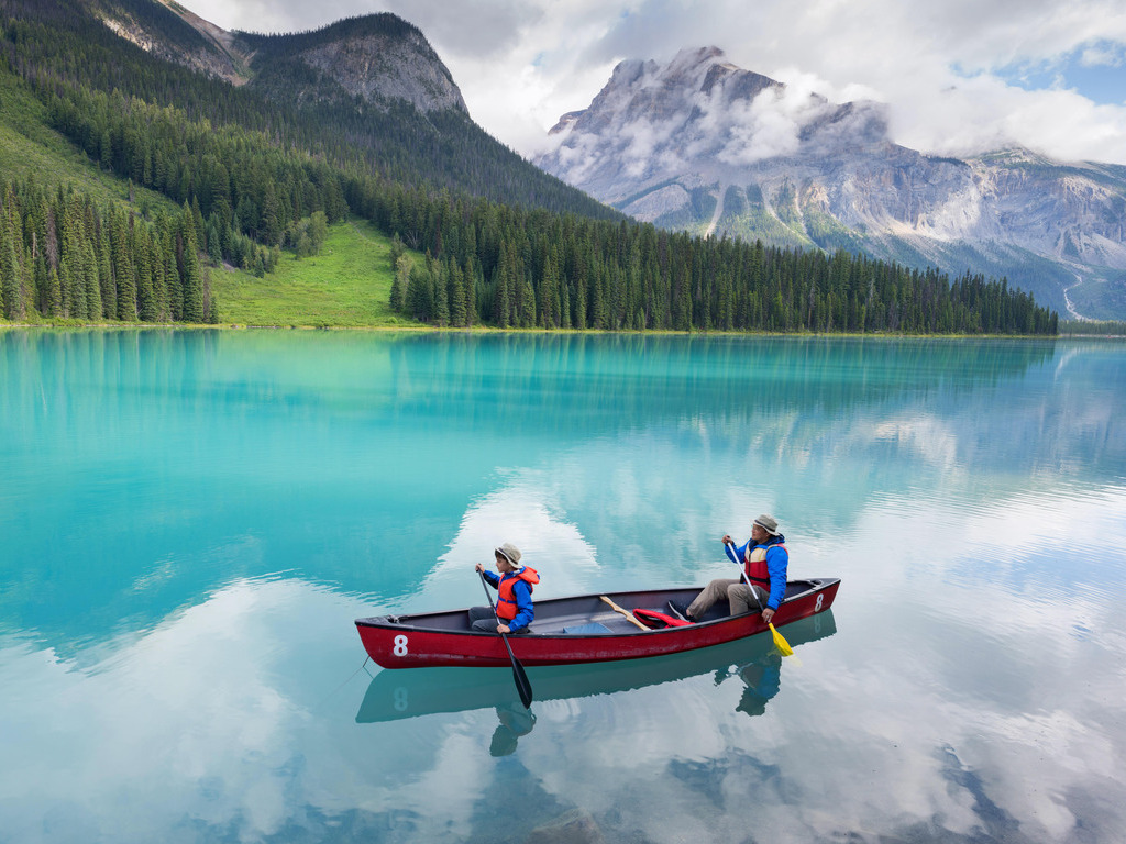 Twee mensen kanoën op het turquoise water van Emerald Lake in Yoho National Park, Canada – reizen met Explore.