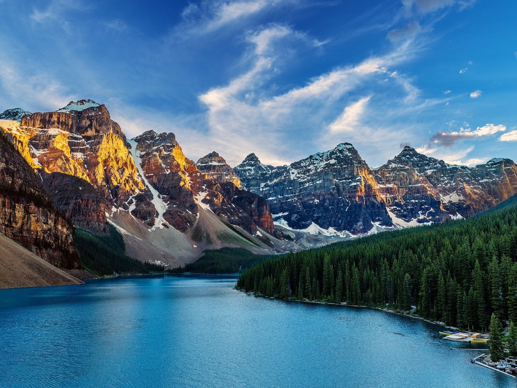 Uitzicht op het blauwe water van Moraine Lake, omringd door dennenbossen en steile rotswanden, met de beroemde Ten Peaks op de achtergrond – Canada – reizen met Explore.