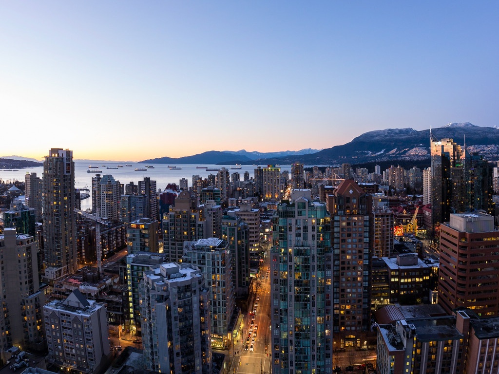 Skyline van Vancouver bij zonsondergang met uitzicht op bergen en oceaan – Canada – reizen met Explore.
