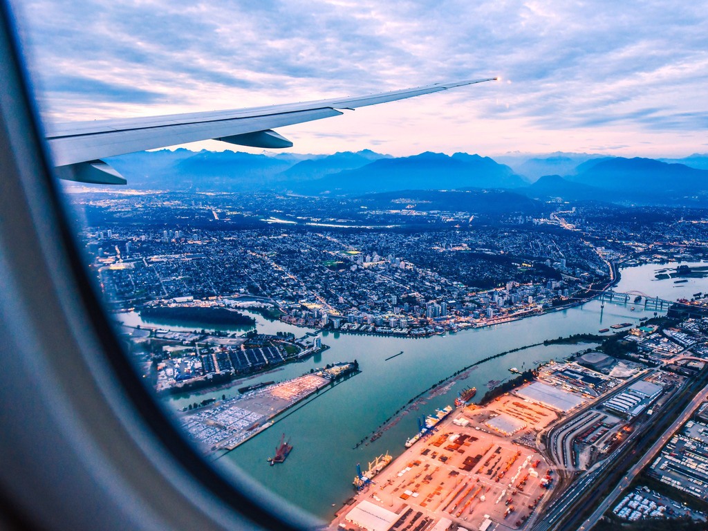 Uitzicht op Vancouver en de haven vanuit vliegtuigraam in British Columbia, Canada – reizen met Explore.