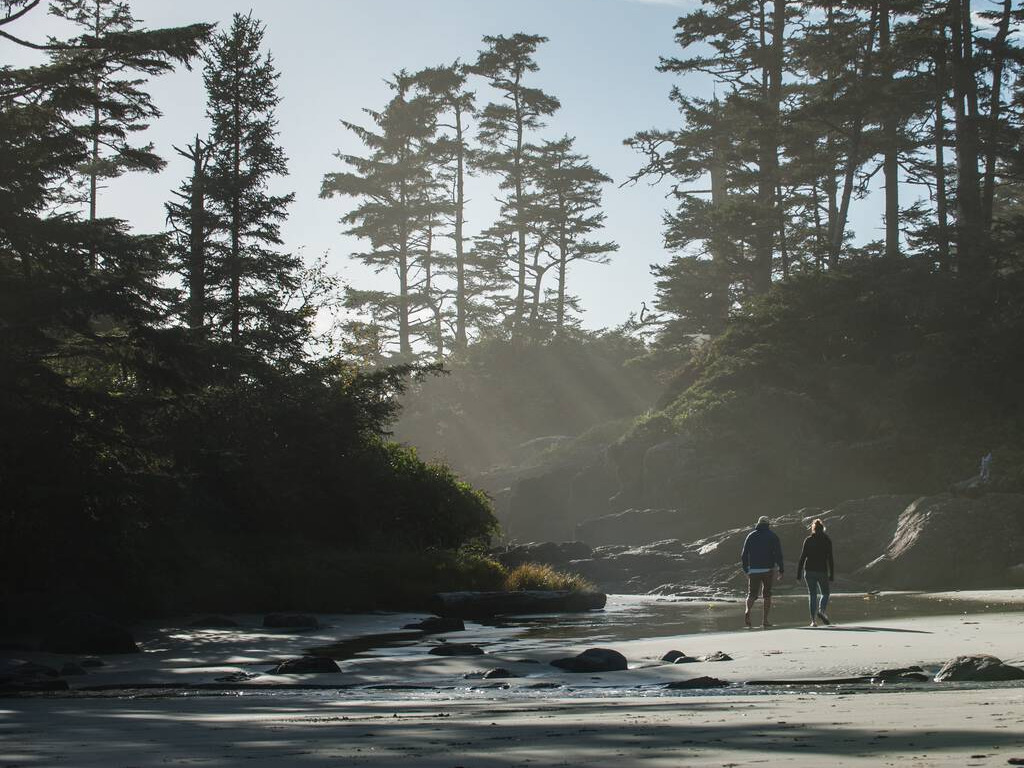 Wandelaars aan de kustlijn in Pacific Rim National Park nabij Tofino en Ucluelet, omringd door bossen en nevelslierten – reizen met Explore.
