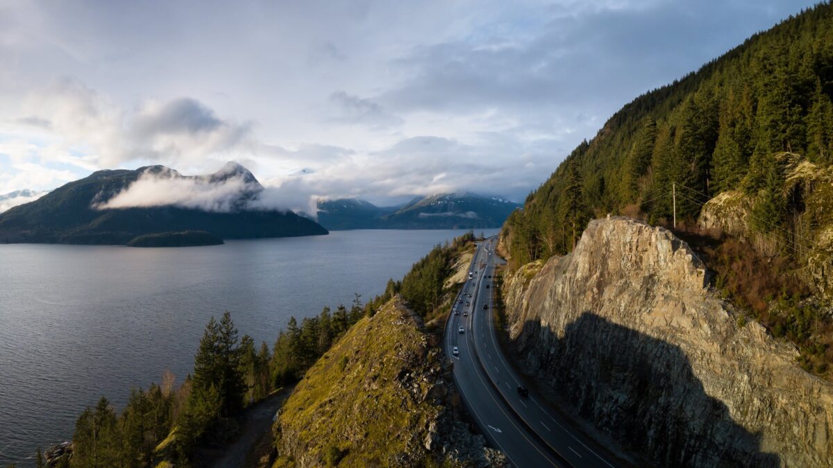 Uitzicht op de kustweg bij Vancouver met omliggende bergen en bossen, Canada – reizen met Explore.