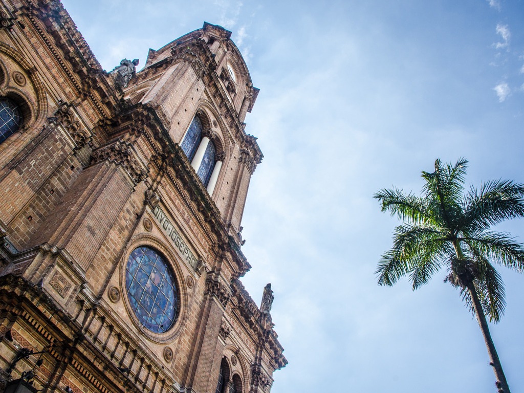 Kathedraal in Medellín met palmboom, Colombia – reizen met Explore.