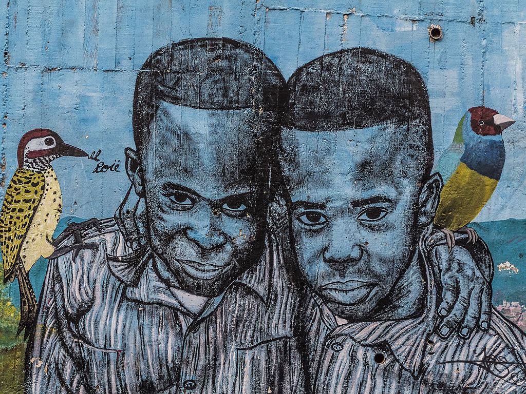 Street art van twee mannen met vogels in Medellín, Colombia – reizen met Explore.
