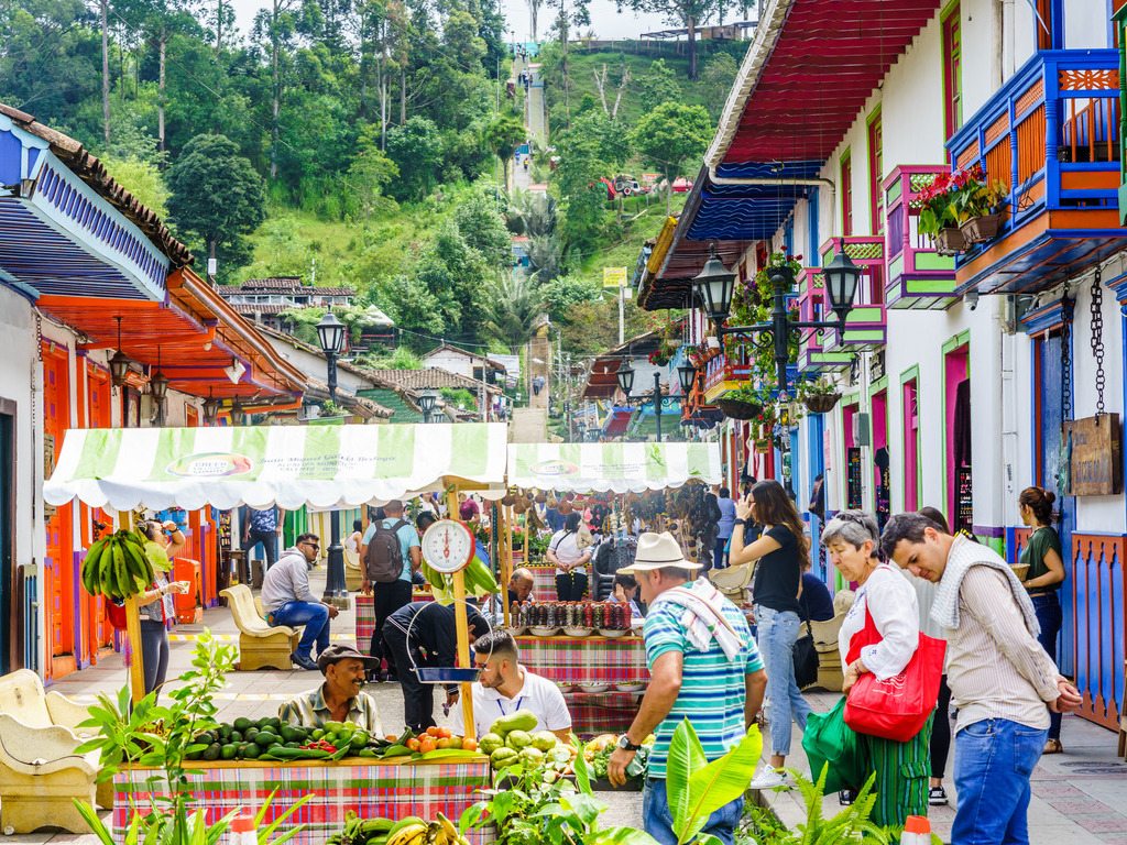 Drukke marktstraat met kleurrijke huizen en mensen in Salento, Valle de Cocora, Colombia – reizen met Explore.