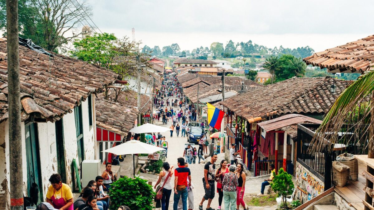 Drukke straat in Salento met kleurrijke huizen en mensen op straat, Colombia – reizen met Explore.