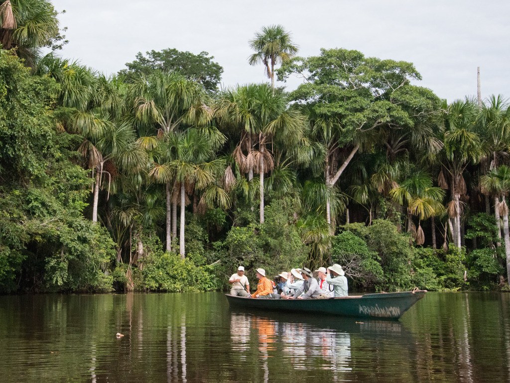 Groep toeristen in kano op rivier in Amazonegebied Tambopata, Peru – reizen met Explore.
