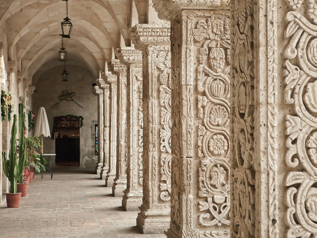 Gedetailleerde stenen zuilen in kloostergang van Arequipa, Peru – reizen met Explore.