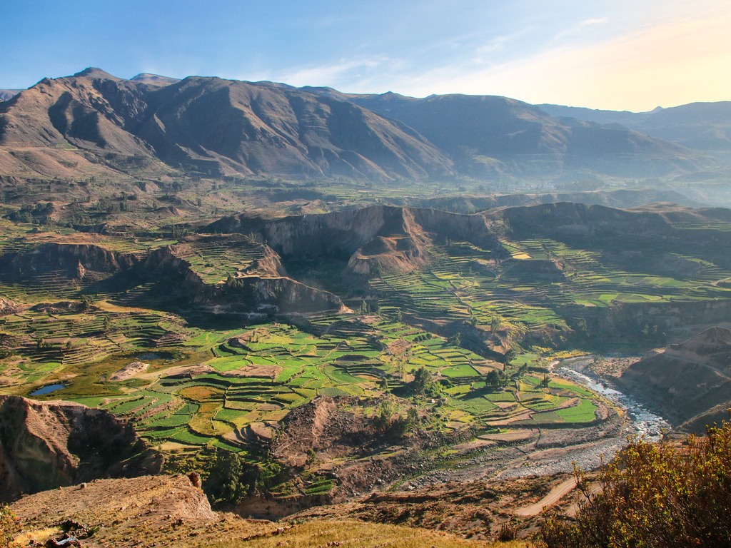 Uitzicht over groene terrassen en rivier in Colca Canyon, Peru – reizen met Explore.