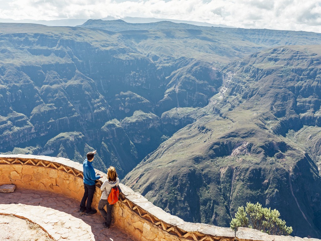 Twee wandelaars kijken uit over de Huanca Urco Canyon bij Chachapoyas, Peru – reizen met Explore.