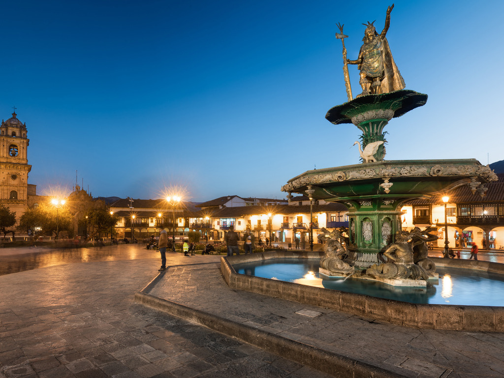 Avondfoto van Plaza de Armas met de Inca-koning Pachacuti fontein, Cusco, Peru – reizen met Explore.