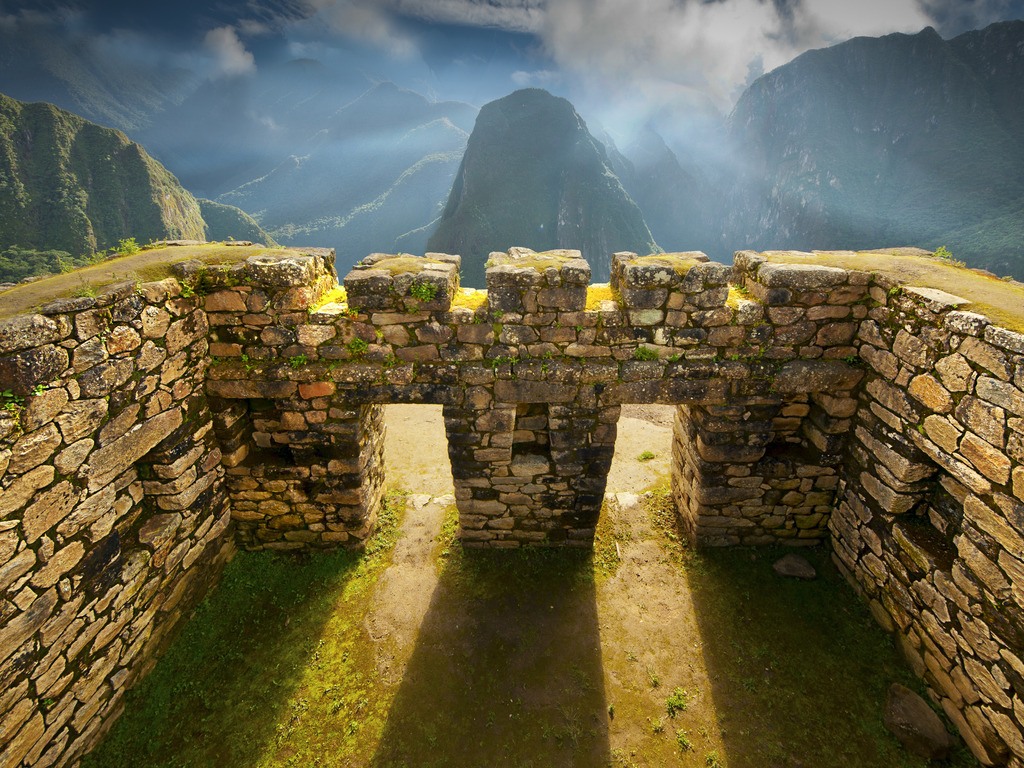 Inca-muur met poorten en zonlicht bij Machu Picchu, Peru – reizen met Explore.