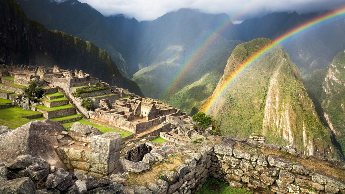 Machu Picchu met dubbele regenboog in de lucht, Cusco, Peru – reizen met Explore.