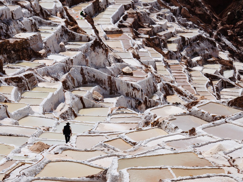 Zoutterrassen van Maras met arbeider, Cusco regio, Peru – reizen met Explore.