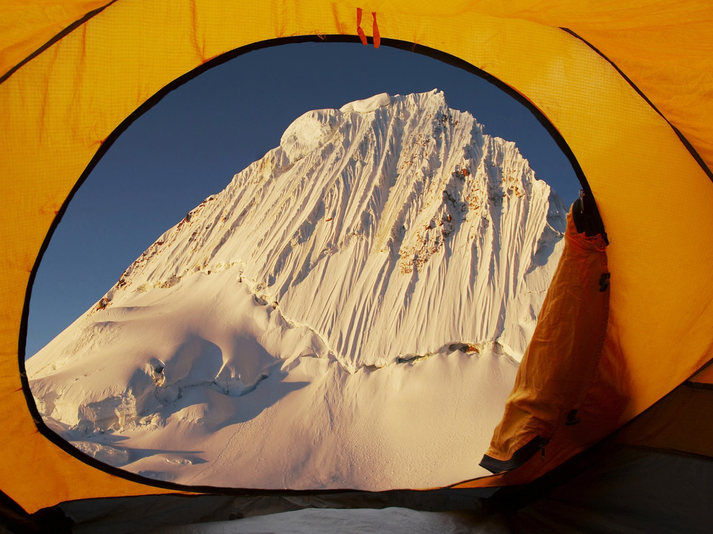 Besneeuwde bergtop gezien vanuit een gele tent in de Andes, Peru – reizen met Explore.