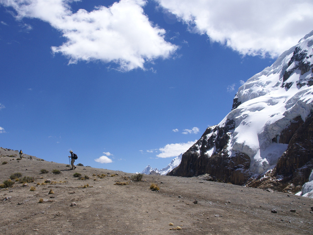 Wandelaar op hooggelegen pad met besneeuwde berg in Huaraz, Peru – reizen met Explore.