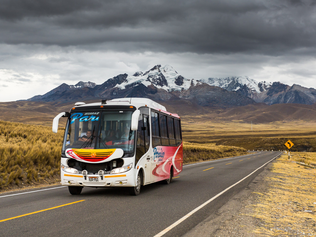 Bus op bergweg met Andes op de achtergrond bij Huaraz, Peru – reizen met Explore.