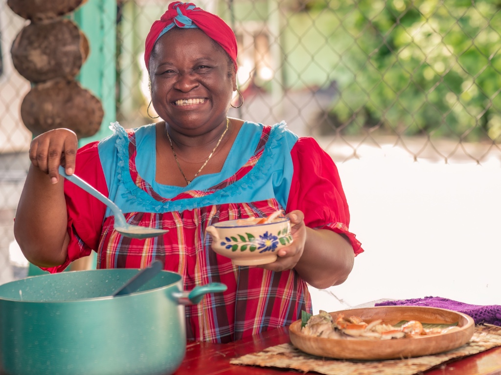 Vrouw serveert traditioneel gerecht in Colombia – reizen met Explore.