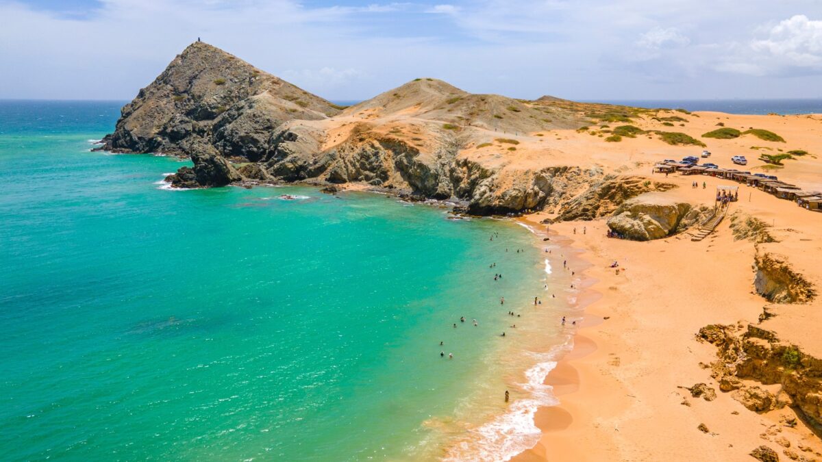 Turquoise zee en oranje zandduinen bij Cabo de la Vela, La Guajira, Colombia – reizen met Explore.