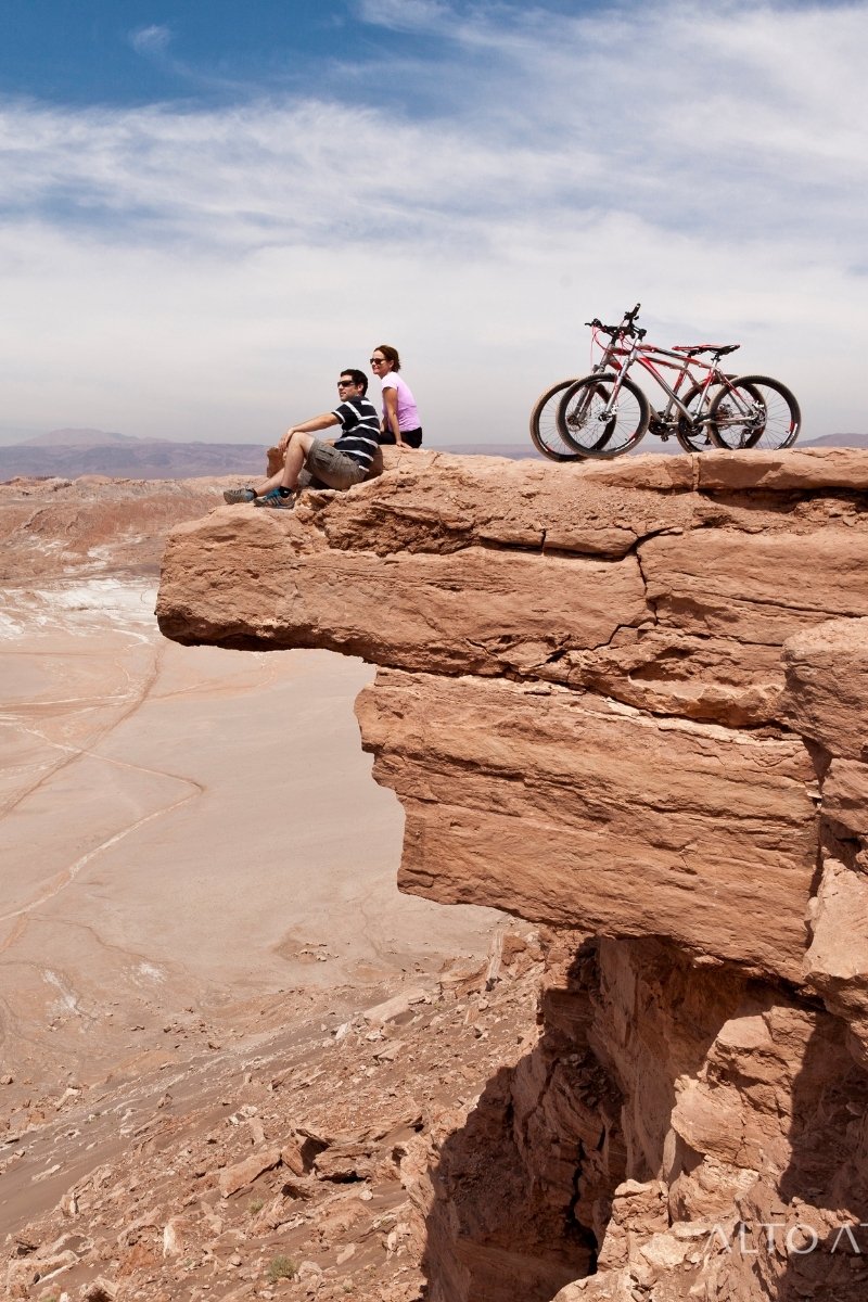 2 personen zitten op een rots tijdens hun mountainbike tocht - reizen met Explore