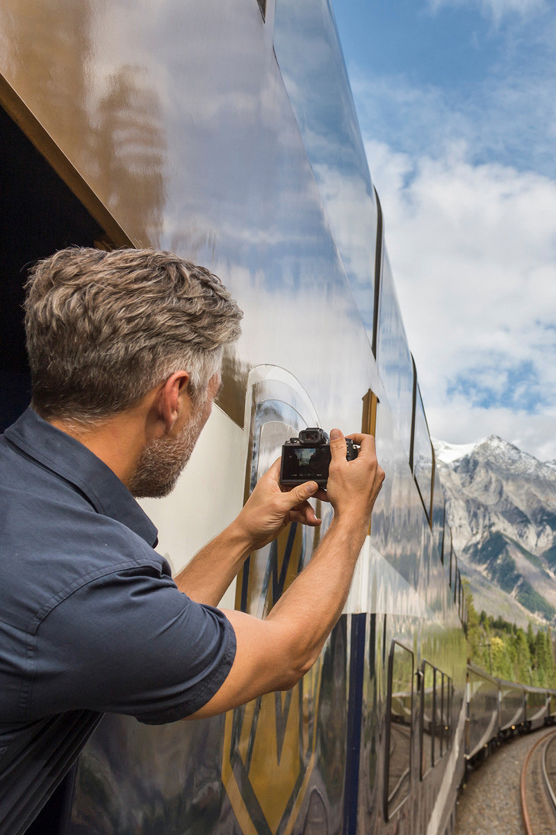 Man die foto maakt vanuit een Rocky Mountaineer trein in Canada - reizen met Explore